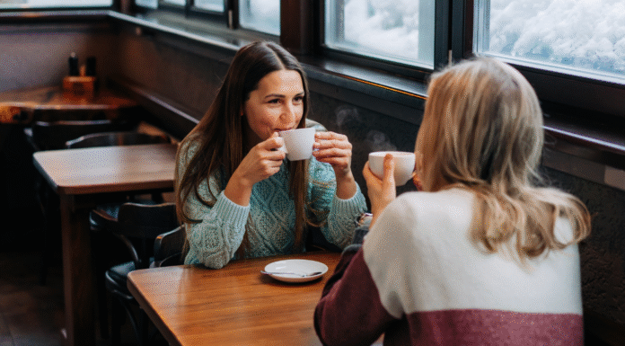 Two women drinking coffee in a coffee shop.