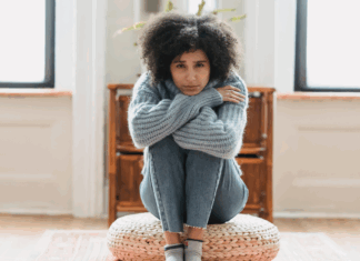 A woman sitting in her grief holding her knees.