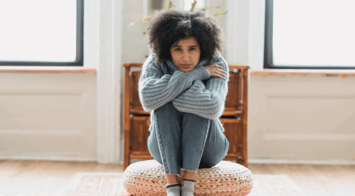A woman sitting in her grief holding her knees.