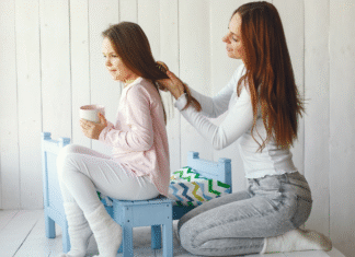 A mom doing her daughter's hair.