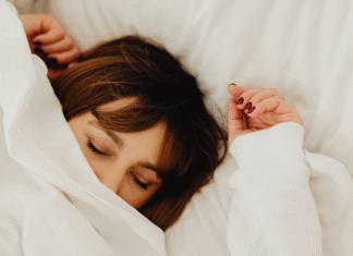 A woman sleeping under covers.