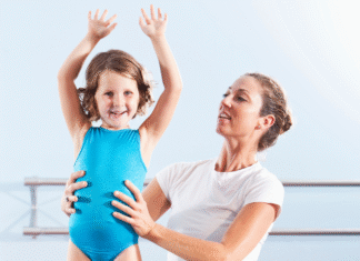 A mom helping her daughter with gymnastics.