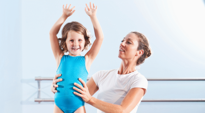 A mom helping her daughter with gymnastics.
