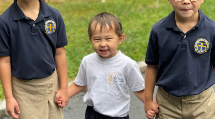 A boy holding hands with his siblings.