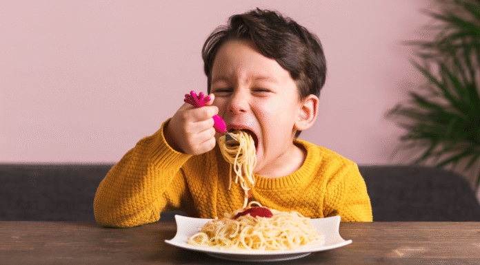 A boy eating a plate of spaghetti.