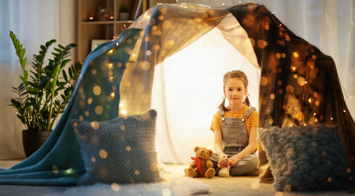 A girl sitting in a fort.