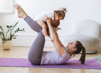 A Guide to Health & Wellness in Fairfield County A woman doing yoga while holding her toddler.