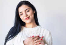 A woman holding her hands to her heart.