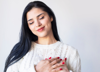 A woman holding her hands to her heart.