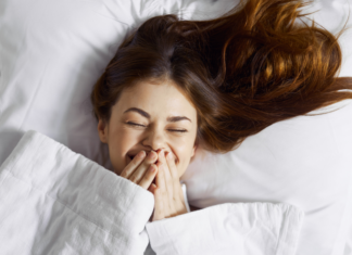 A Teenager laughing in bed.
