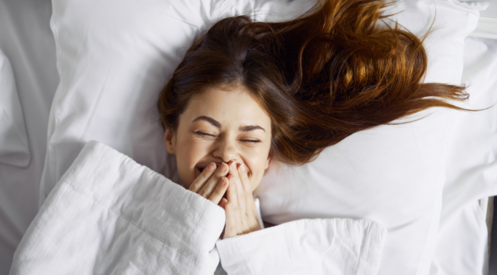 A Teenager laughing in bed.