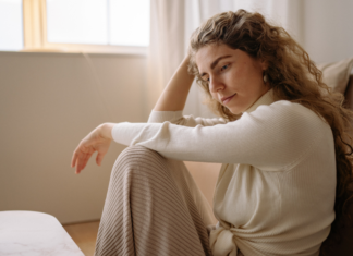 A woman sitting on the floor thinking.