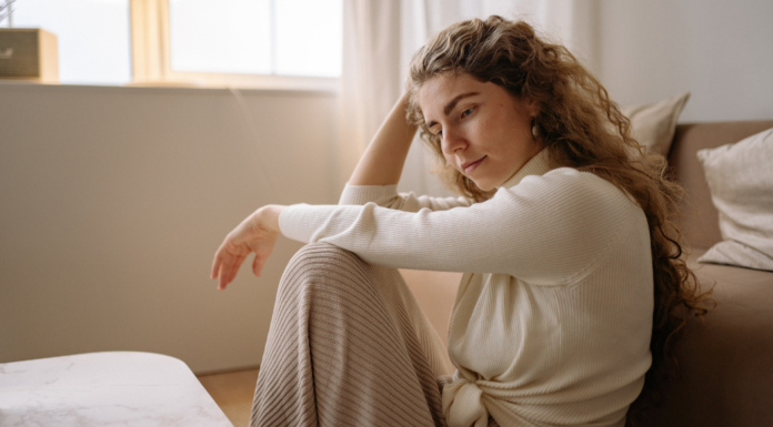 A woman sitting on the floor thinking.