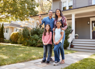 A family standing outside of their home.