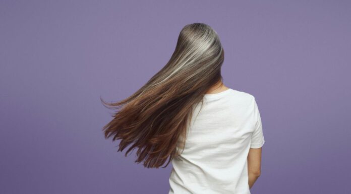 A woman growing out her gray hair.