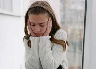 A sad girl holding her face.