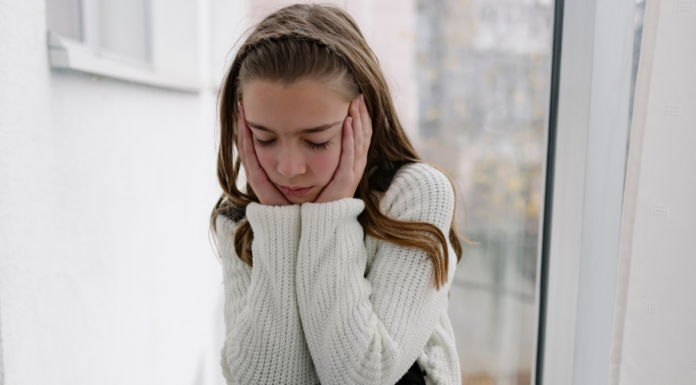 A sad girl holding her face.