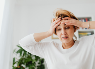 I’m Not Unmotivated, I’m a Mom in February A stressed mom holding her head.