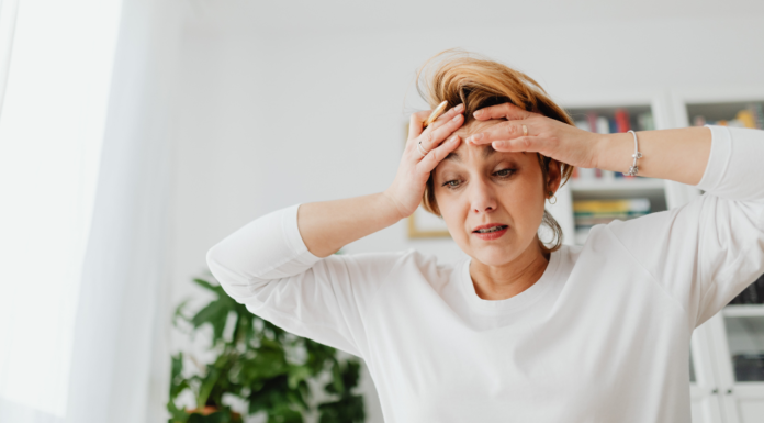 I’m Not Unmotivated, I’m a Mom in February A stressed mom holding her head.