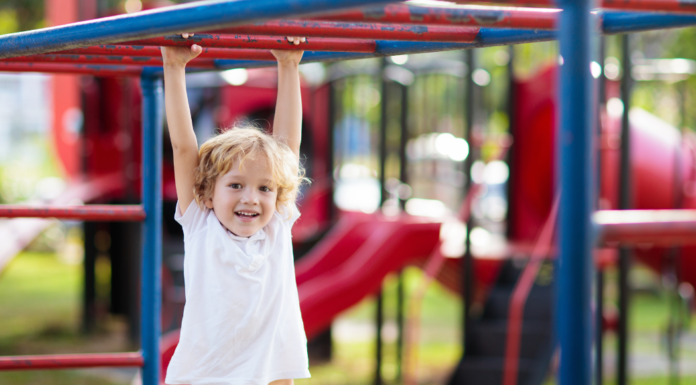 10 Essential Playground Safety Tips Every Parent Should Know A boy hanging on the monkey bars.