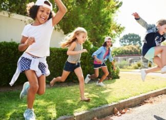 Kids playing outside and jumping off the curb.