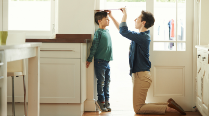 A mom measuring her child's height.