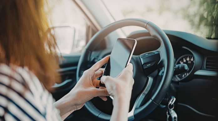 A woman on her phone sitting in her car.