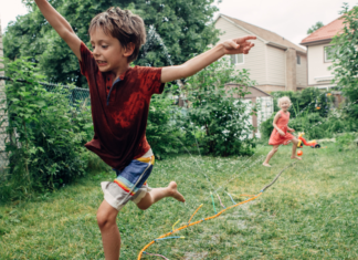 Kids running through a sprinkler.