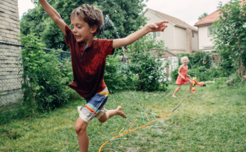 Kids running through a sprinkler.