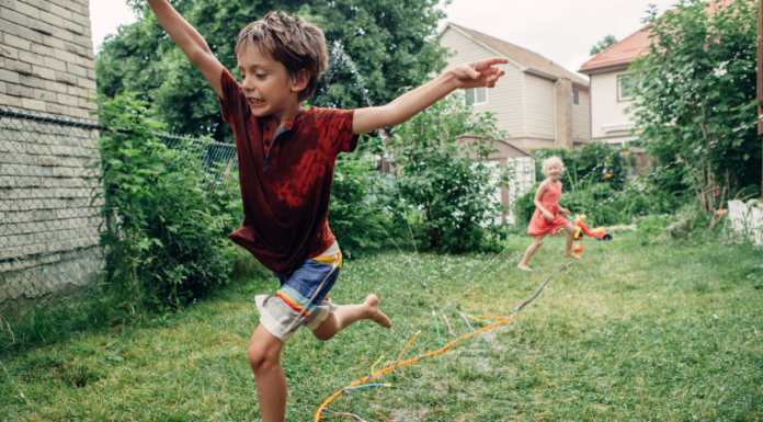 Kids running through a sprinkler.