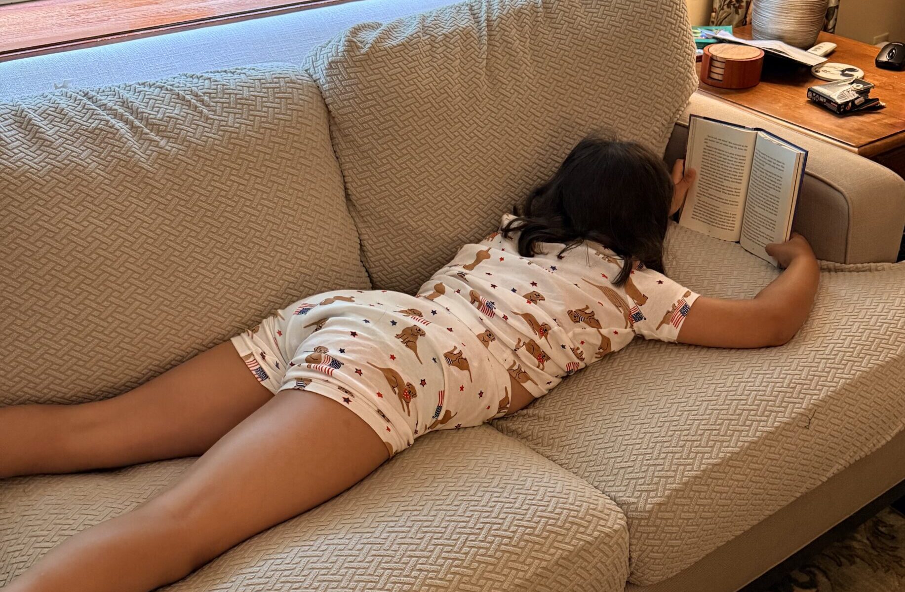 A girl reading on the couch. 
