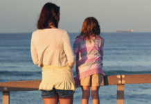 A woman and girl looking out over a dock.