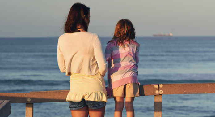 A woman and girl looking out over a dock.
