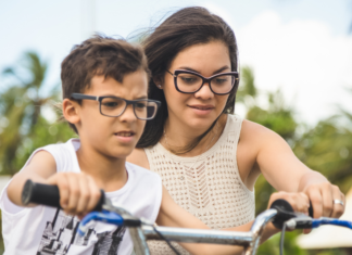 Why I Am a Helicopter Parent (And Not Bothered at All) A mom helping her son ride a bike.
