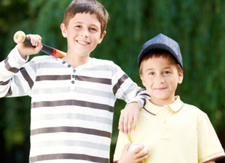 Boys holding a baseball and ball.