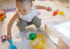 A girl playing in the sand with toys.