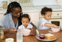 A mother eating breakfast with her children.