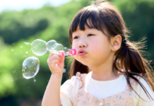 Bubbles: The Easiest Summer Magic for Little Kids A girl blowing bubbles.