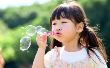 Bubbles: The Easiest Summer Magic for Little Kids A girl blowing bubbles.