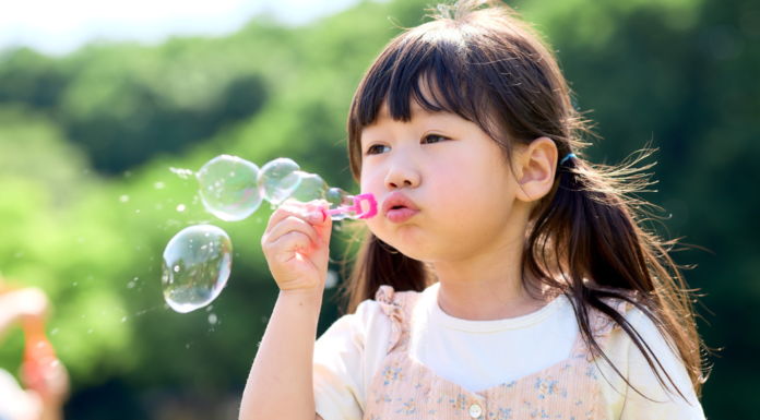 Bubbles: The Easiest Summer Magic for Little Kids A girl blowing bubbles.
