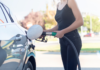 A woman pumping gas.