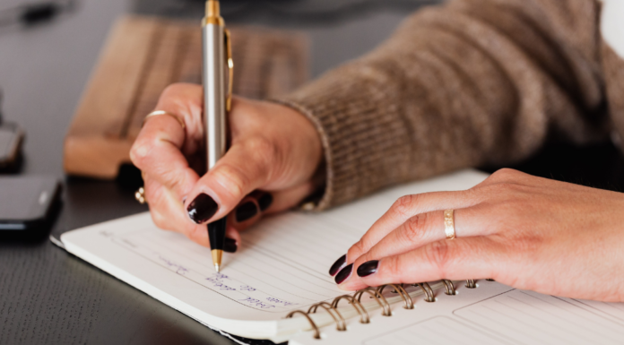 Writing with a pen in a journal.