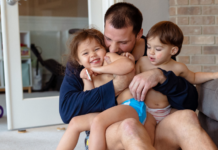 It’s Not Babysitting When It’s YOUR Kids A dad holding his children.