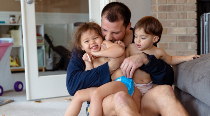A dad holding his children.